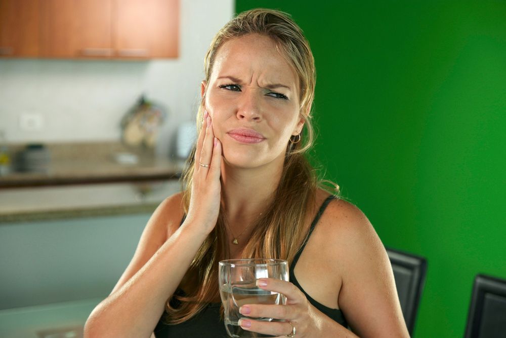 Woman holding jaw in pain
